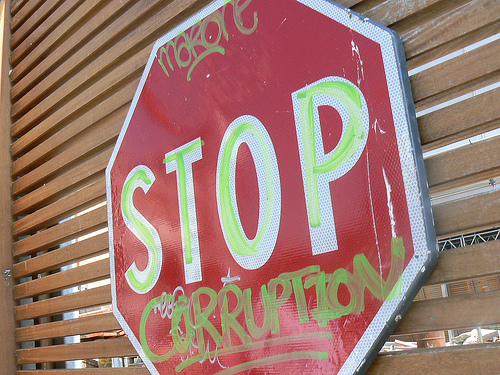 Spray painted Stop Corruption sign