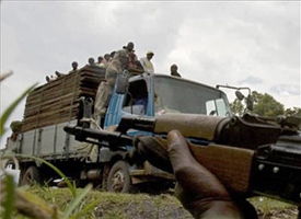 truck loaded with people and machine gun in the foreground