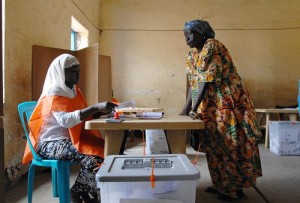 An official from Sudan's National Elections Commission (left) assists a voter at a polling station in Juba, Sudan.
