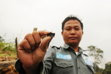 A deminer holds a fragment from a BLU 26 cluster munition which can travel approximately 150 metres.Savannakhet Province, Laos 2010 - by CMC under CC Licence
