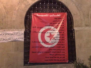 La lista de las 'demandas populares' de los manifestantes en el plantón escritas en la bandera tunecina. Foto de Winston Smith.