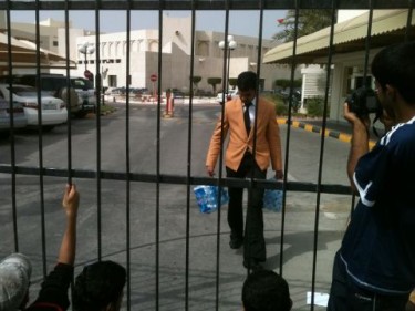 Personal del Consejo Al-Shura trae botellas de agua para los manifestantes fuera del edificio del Consejo Nacional.