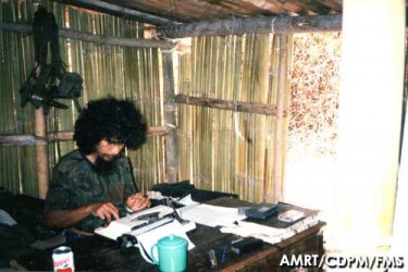 Santana typing in a shelter. By Comissão para os Direitos do Povo Maubere, Arquivo Museu da Resistência Timorense.