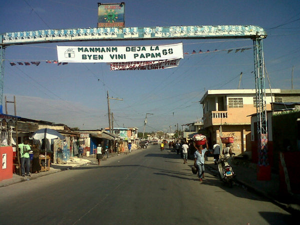 @etiennecp: "#Manigat trying to please #Aristide supporters in Cité Soleil w/ welcome banners."