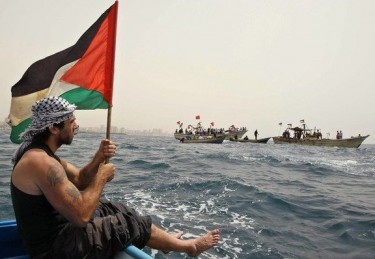 Vittorio Arrigoni memegang bendera Palestina
