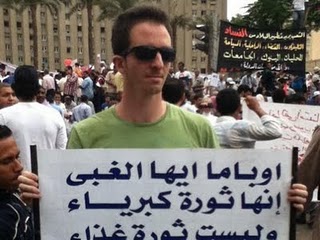 Ilan Grapel in Tahrir Square carrying a poster which calls US President Barack Obama stupid. Source, Ilan Grapel's Facebook account.