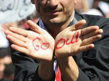 An anti-government protester outside Sana'a University shows the words 'Go Out' to Yemen's President Ali Abdullah Saleh. Image by Flickr user AJTalkEng (CC BY-NC-ND 2.0).