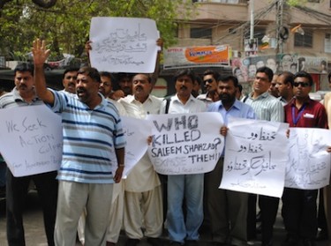 People hold placards demanding an investigation into the killing of Saleem Shahzad. Image by Rajput Yasir, copyright Demotix (01/07/2011).)