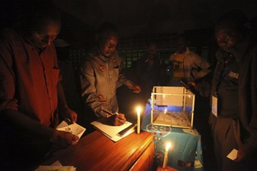 An electoral official checks an election result sheet using a lantern after the Presidential election in Yaounde, Cameroon, Sunday, October 9. 2011 - www.africathroughalens.com 