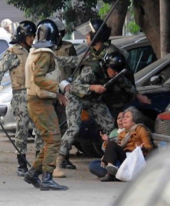 Immagine condivisa da Ahmed Shokeir su Twitter, un soldato egiziano mentre sta per colpire una donna anziana