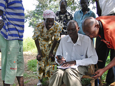 Flüchtlinge in Uganda nutzen Handys mitsamt ihrer SMS-Funktion, um mit Familienangehörigen und Freunden zu kommunizieren. Foto von MobileActive 