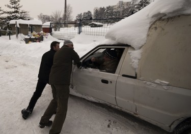 Bosnian men are trying to push a car away from the deep snow. Photo by Sulejman Omerbasic, copyright © Demotix (5/02/12).