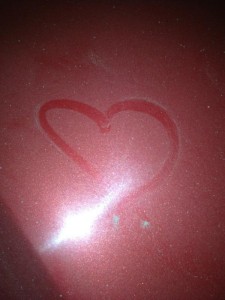 المصرية نرمين إدريس تجد قلباً مرسوماً على سيارتها الحمراء.