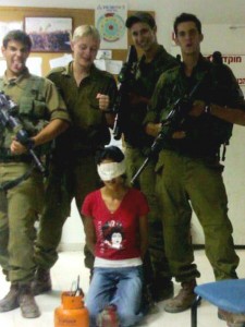 يقف الجنود الإسرائيلين مع فتاه فلسطينية شابة كرهينة.