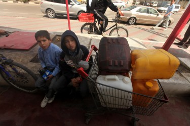 Palestinians wait to fill containers with fuel. Image by Majdi Fathi, copyright Demotix (21/03/2012).