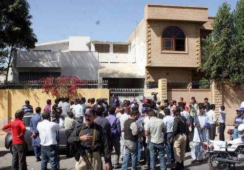 People gather at the house where the dead bodies of five people were found. Image by PPI Images. Copyright Demotix.