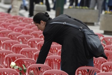 A Bosnian woman, Berina Hodzic, lays a flower on one of the red chairs that were installed along Sarajevo's main street to mark the 20th anniversary of the start of the Bosnian War. Photo by SULEJMAN OMERBASIC, copyright © Demotix (04/06/12).