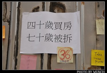 A poster outside Wang's houses. It says 'my house was bought when I was 40, and it was torn down when I was 70.' Photo by Flickr User munch999 (CC BY-NC-SA 2.0).