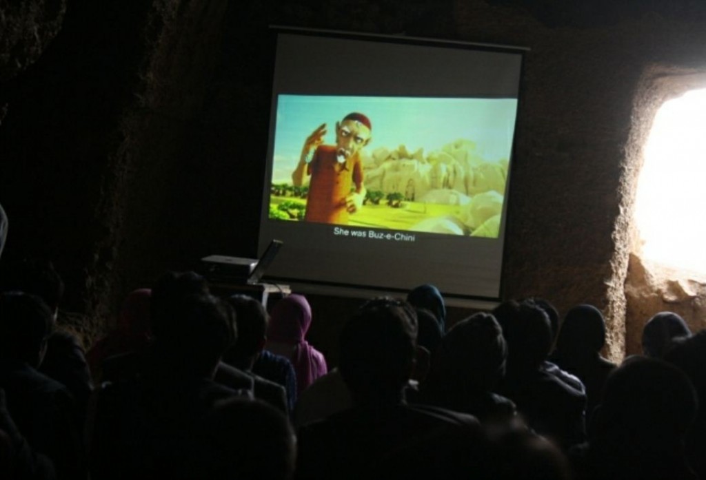 شاهد أطفال من باميان "بزِ تشيني" على شاشة نصبت في الكهف. رفعت الصورة بواسطة طاهرة باخشي (جمهورية الصمت)، استخدام مرخَّص.