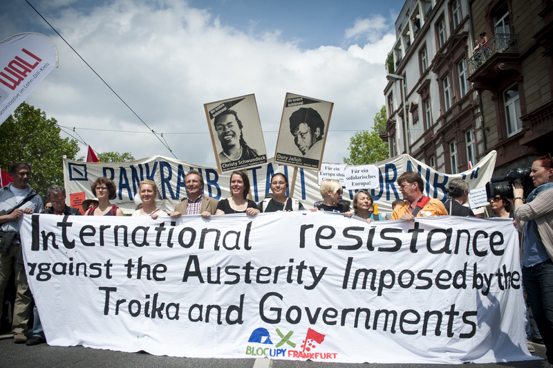 Демонстрация Blockupy във Франкфурт. Голям банер, гласящ: 'Международна съпротива срещу строги икономии, наложени от Тройката и правителствата.'. Снимка от Микеле Лапини в Demotix (19 май, 2012 г.).