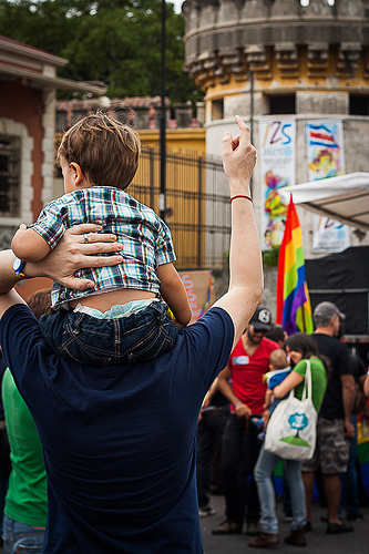 Man carries a baby on his shoulders during the Invisibles March in Costa Rica