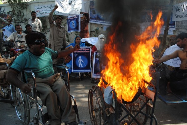 Disabled protesters set a wheelchair on fire during demonstrations against social welfare cuts