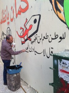 Artists painting murals on Mohamed Mahmood Street in Cairo after police erased them 
