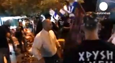 Screenshot from a video in which members of Greece's extreme-right Golden Dawn party pose as police to check migrant market traders' papers - and then attack a stall.