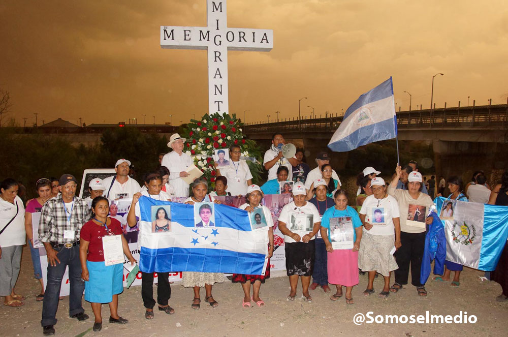 Central American mothers participating in the caravan make and offering at a cross in memory of the migrants. 