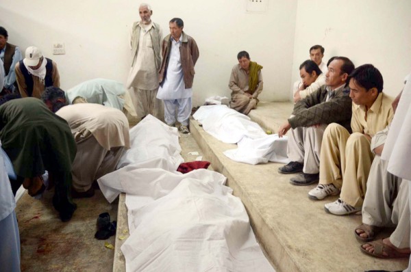 People gather near the dead bodies of victims, who were gunned down by unidentified armed men at the Scrap Market on Sarki Road in a target killing. Quetta, Pakistan. 16th October 2012  Image by PPPIimages. Copyright Demotix