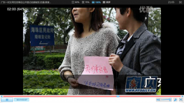 A lesbian couple holding a sign that says "we want to get married." (A screenshot from youku)