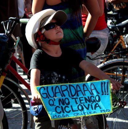 Image by Gianluca Casanova from Facebook (CC). Child during demonstration in Montevideo, Uruguay.  Sign says: "Watch ooout! because I don't have a bike line. Critical Mass Montevideo"