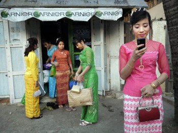 College graduates in Maiktila, Myanmar leaving a beauty salon. Image by Geoffrey Hiller. Used with permission