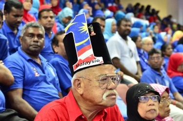 A supporter of the ruling party listens to the speech of the Prime Minister. Photo by Asyraf rasid, Copyright @Demotix (4/6/2013)
