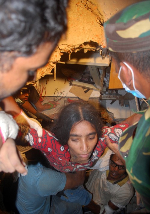 A female worker is being pulled out by civilian volunteers and  members of armed forces. Image by Rehman Asad. Copyright Demotix (26/4/2013)