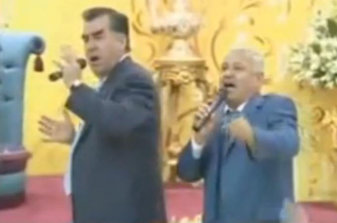 Rahmon (left) performs at his son's wedding. Screenshot from video uploaded by PolitikTJ