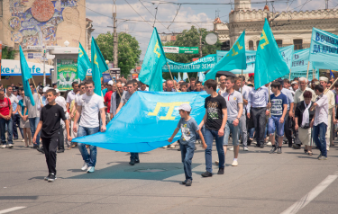 Crimean Tatar men carry their national flag at the May 18 commemoration of the 1944 Crimean Tatar deportations. Photo by Andy Ignatov (used with permission).