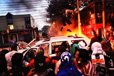 Impedidos de se aproximarem do estádio em Belo Horizonte, manifestantes colocam fogo em veículos importados numa franquia de loja de carros