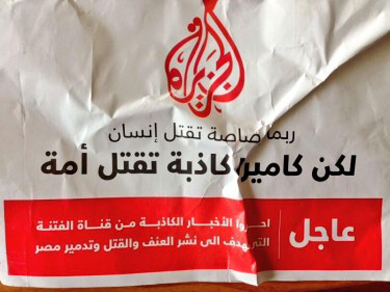 كاميرة كاذبة تقتل أمة. عبارة تُقرأ على أحد المنشورات التي القيت خارج مكتب الجزيرة في القاهرة. صورة نشرت في تويتر عبر @RawyaRageh 