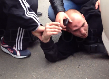 Anton Kudriashov lies in the road after being attacked, 27 July 2013, screenshot from YouTube.