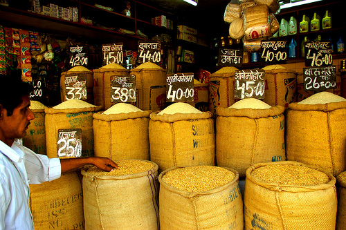A customer in Mumbai, India inspects food grains before making his purchase