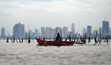 A fisherman gathers mussels on the waters of Manila Bay. Photo by Ezra Acayan, Copyright @Demotix (7/14/2013)