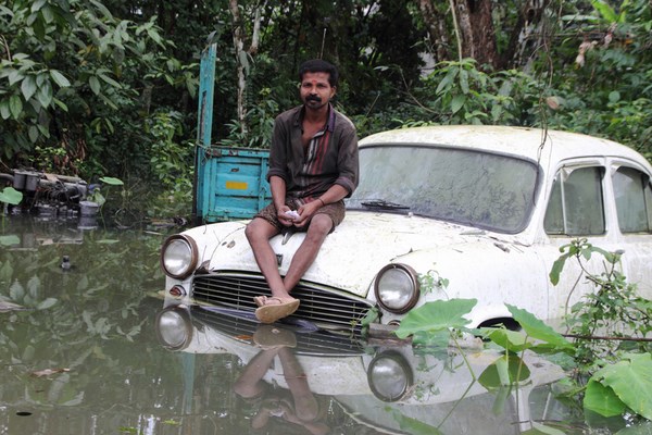 In South Kerla an unidentified man sitting on a car submerged in flood water