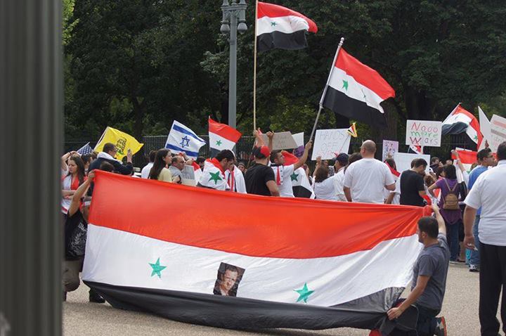 A pro-Assad protest in Washington DC. In addition to waving the Syrian flag, an Israeli flag is seen among the crowd. Photograph shared by Eiad Charbaji on his public Facebook page 