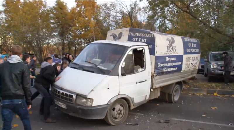 Rioters tipping over a delivery truck in Western Biryulyovo during recent unrest in the Moscow neighborhood. YouTube screenshot.