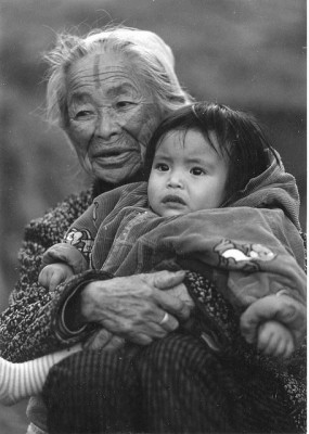 Una mujer Atayal con un tradicional tatuaje facial alzando a su nieta. Fotografía tomada por atonny.