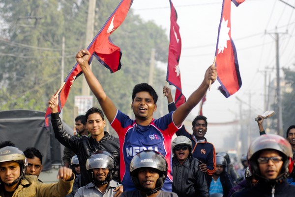 Young Nepali cricket fans raise the national flag to celebrate their surprise qualification for the Twenty20 World Cup final in 2014. Image by Manish Paudel, Copyright Demotix (28/11/2013)