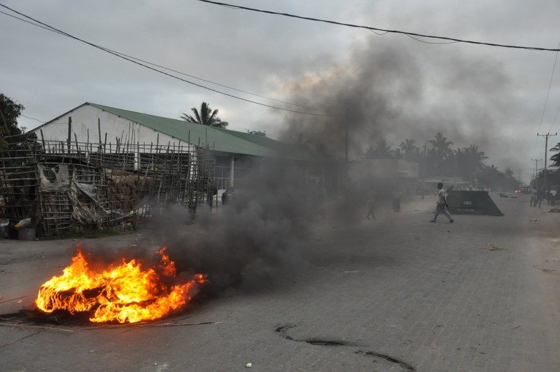 Após o ataque da força policial, a multidão ateou fogo a pneus nas vias que levavam ao bairro da Munhava, na Beira. 
