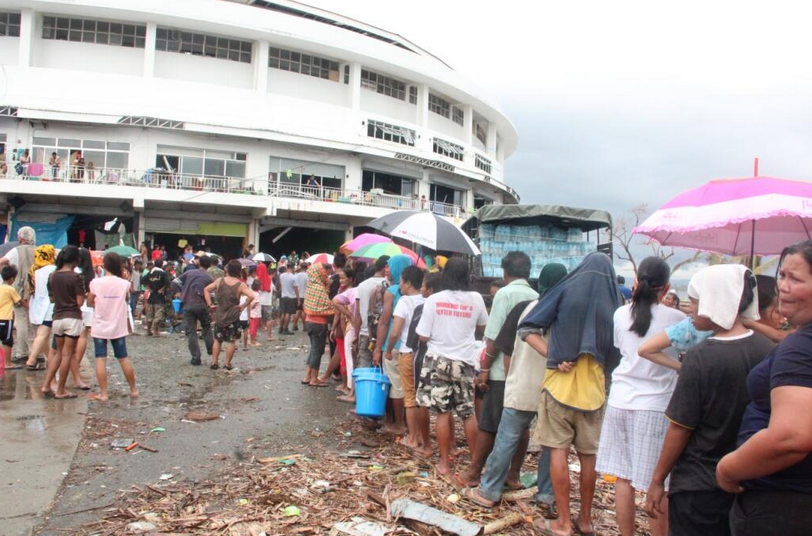 Tacloban typhoon survivors wait in line during a relief distribution. Government photo