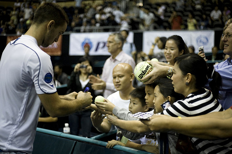 Viktor Troicki signing autographs at PTT Thailand Open 2009; photo courtesy of Government of Thailand, used under Creative Commons 2.0 License.
